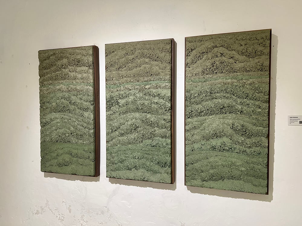 Three unfired green rammed earth clay panels by Adam Weismann installed on a white gallery wall, showing layered mineral tones and compressed texture. Matiz Gallery, London. 2026.