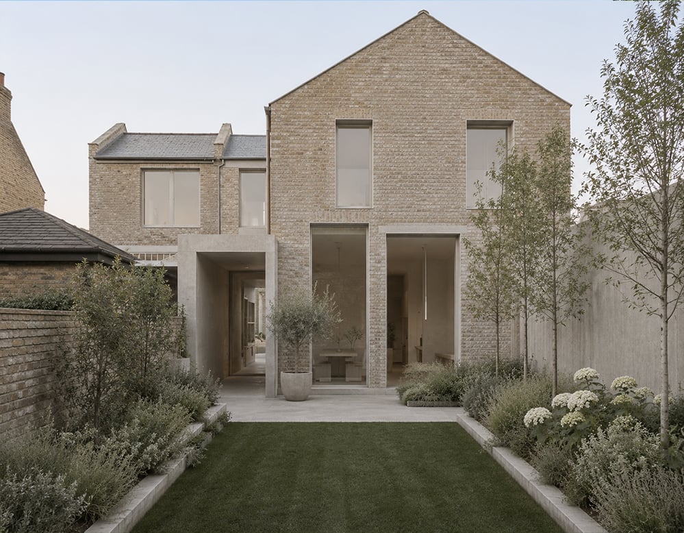 Contemporary rear extension to a London townhouse featuring pale brickwork, large recessed windows, minimalist detailing and a landscaped courtyard garden designed to maximise light, space and connection to nature.
