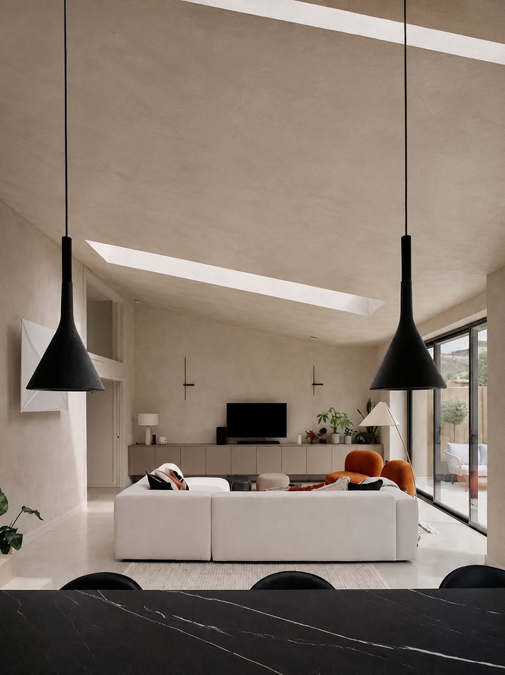 Minimal contemporary living room with clay plaster walls, rooflights, natural textures, large sliding doors, and low-energy architectural detailing in a sustainable London home renovation.