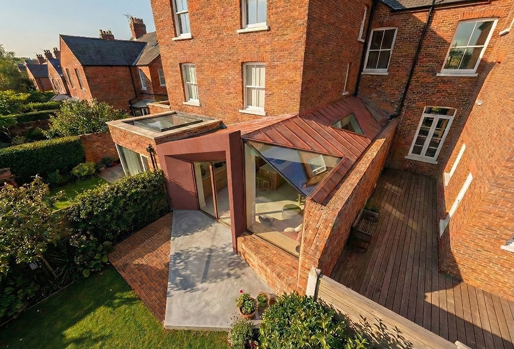 Aerial view of a low-energy Victorian house extension in London, showing folded roof geometry, solar-ready roof planes and a contemporary rear addition designed using a fabric-first retrofit approach.