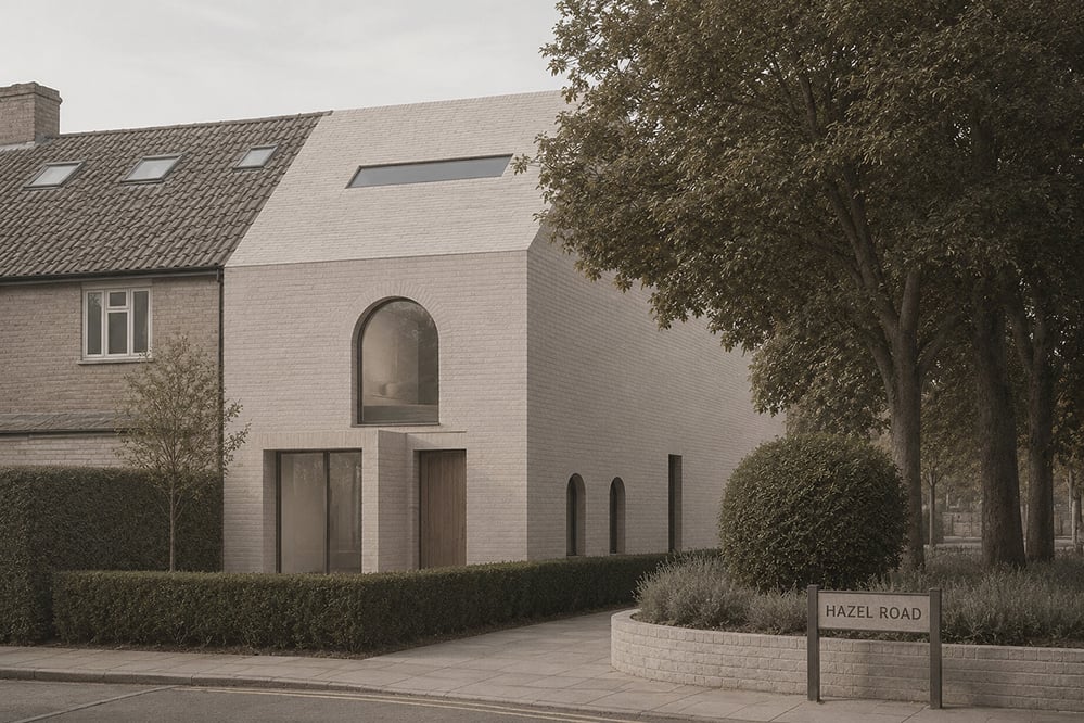 Contemporary pale stock brick infill house by RISE Design Studio on Hazel Road, Kensal Green, with a tall arched first-floor window, zinc roofline and clipped hedge frontage, set beside a traditional pitched-roof terrace, with a Hazel Road street sign in the foreground.