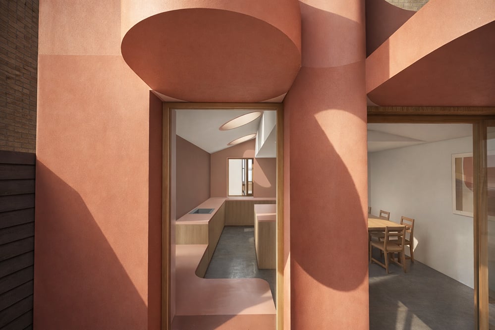 Close detail of cylindrical pink render forms and circular rooflight at Scallop House rear extension, Stoke Newington, designed by RISE Design Studio.