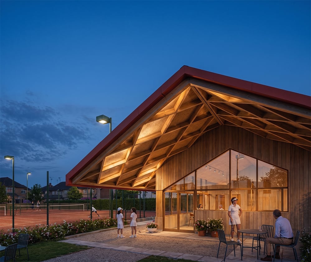 Dusk view of Sutton Churches Tennis Club pavilion by RISE Design Studio, showing exposed glulam timber roof structure and vertical timber cladding with courts beyond.