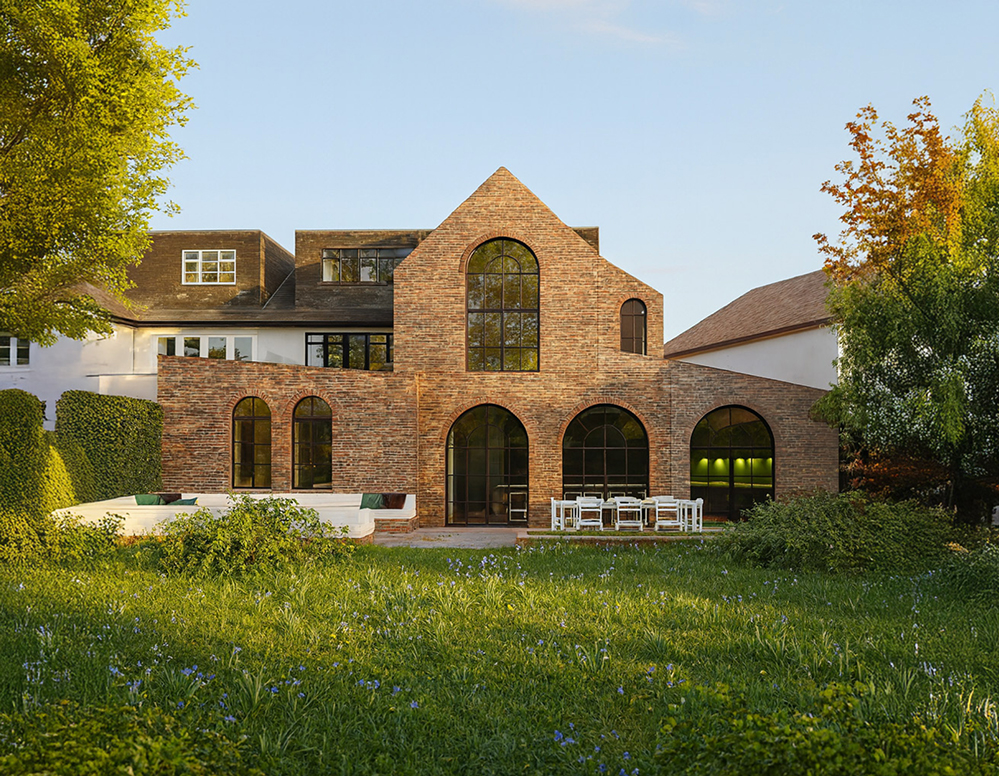 Two-storey brick side and rear extension in West Hampstead with arched steel-framed windows opening onto a landscaped garden terrace, designed by RISE Design Studio for contemporary family living.