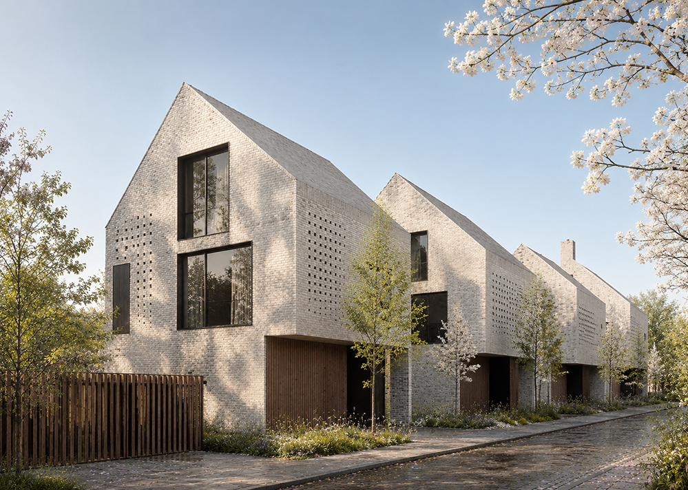 A terrace of contemporary gable-fronted houses in pale grey brick, with perforated brickwork panels, full-height windows and recessed timber-clad entrance bays, set behind young trees and planting along a cobbled street in blossom. RISE Design Studio.